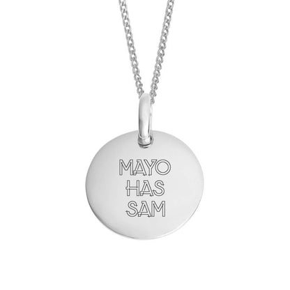 A silver round disc pendant necklace engraved with the text 'MAYO HAS SAM' in a thin outlined font, suspended from a silver chain against a plain white background.