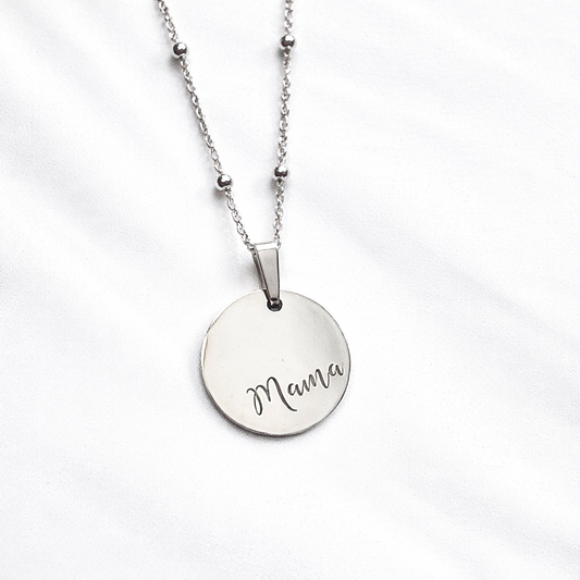 Round silver disc with Mama engraved on a silver bead chain on a white background
