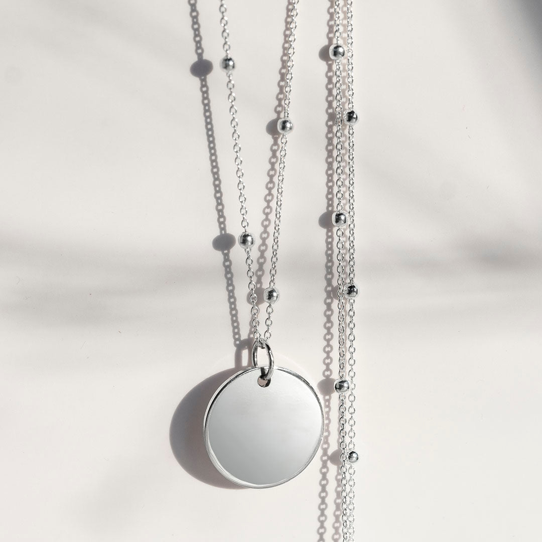Silver disc pendant on a satellite chain
