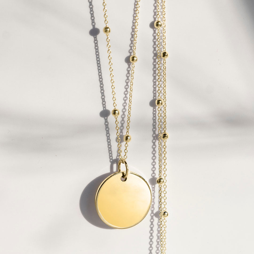 Gold disc pendant on a satellite chain