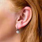Silver hoop earrings with heart charm shown on model