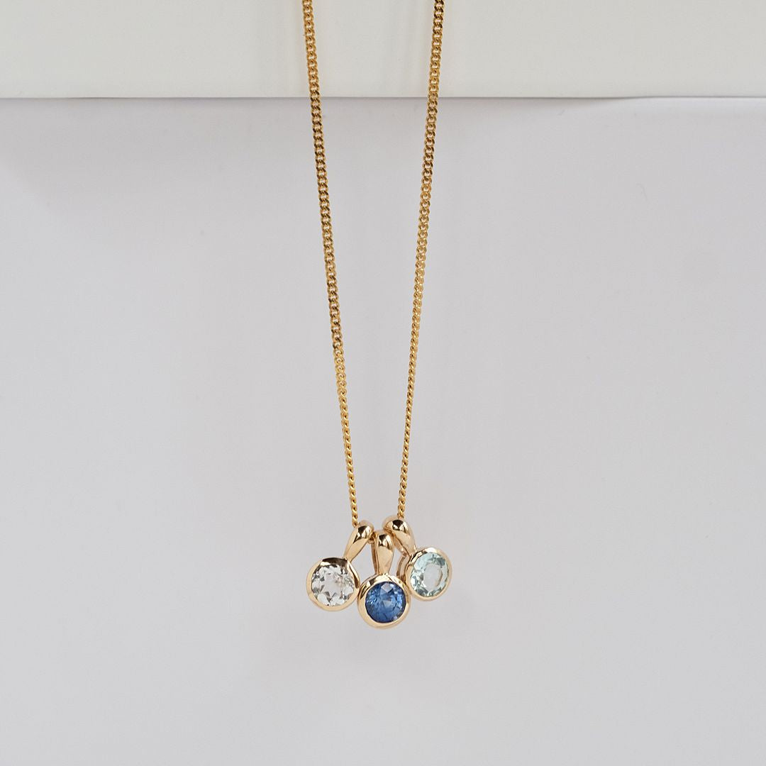 White topaz, sapphire and aquamarine birthstone charms on a chain
